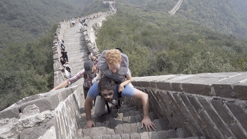 Kevan's friends carrying him up the Great Wall of China