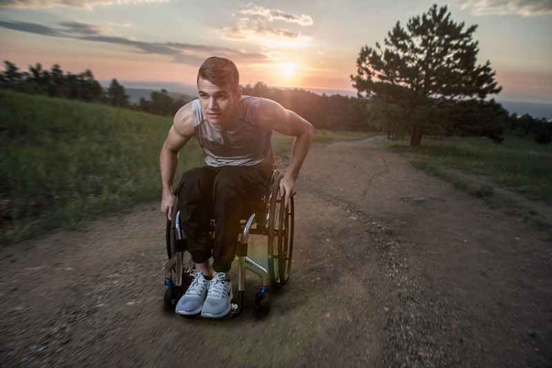 A man exercises outdoors in his wheelchair